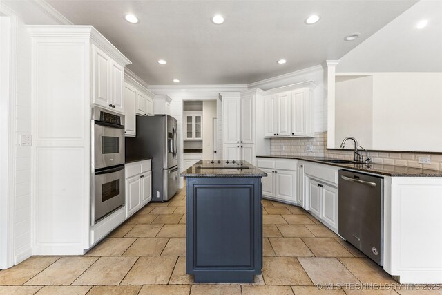 1505 Augusta, Ada, OK 74820 - kitchen with appliances with stainless steel finishes, a kitchen island, ornamental molding, tasteful backsplash, and white cabinetry