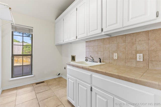 1505 Augusta, Ada, OK 74820 - laundry room with cabinet space, hookup for a washing machine, light tile patterned floors, and hookup for an electric dryer
