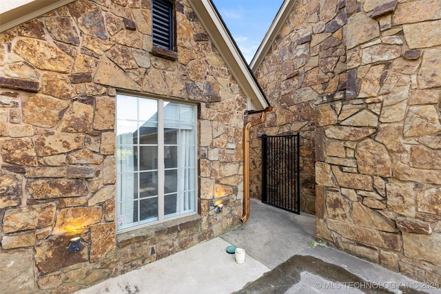 1505 Augusta, Ada, OK 74820 - doorway to property featuring stone siding and a gate