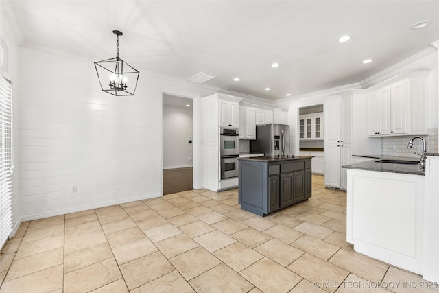 1505 Augusta, Ada, OK 74820 - kitchen featuring stainless steel appliances, white cabinets, a center island, decorative backsplash, and a chandelier