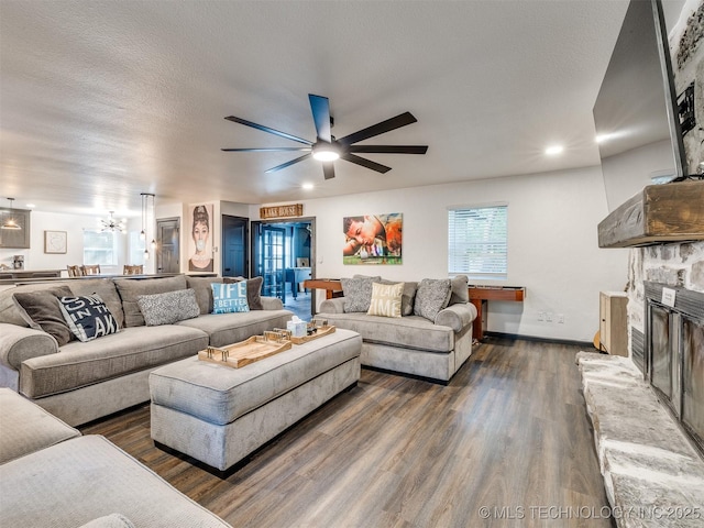 11 Port Duncan, Afton, OK 74331 - living room featuring dark wood-style flooring, ceiling fan, a stone fireplace, and a chandelier
