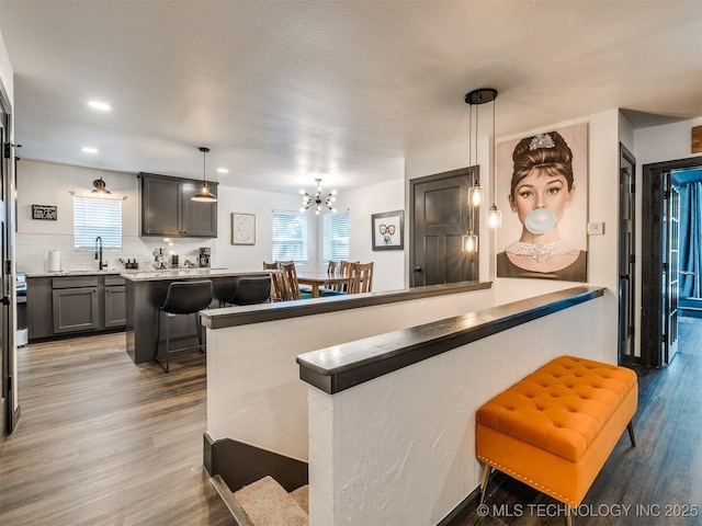 11 Port Duncan, Afton, OK 74331 - kitchen with a kitchen bar, wood finished floors, a chandelier, decorative light fixtures, and recessed lighting