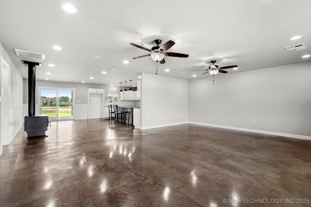 36619 W 141st St S, Bristow, OK 74010 - unfurnished living room featuring a wood stove, finished concrete flooring, a ceiling fan, and recessed lighting