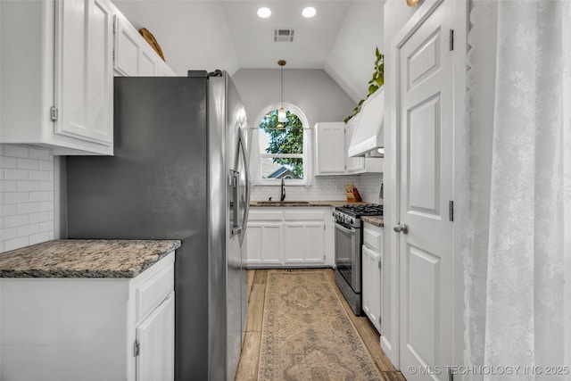 19912 E 36th St S, Broken Arrow, OK 74014 - kitchen with appliances with stainless steel finishes, wood finished floors, white cabinets, backsplash, and lofted ceiling