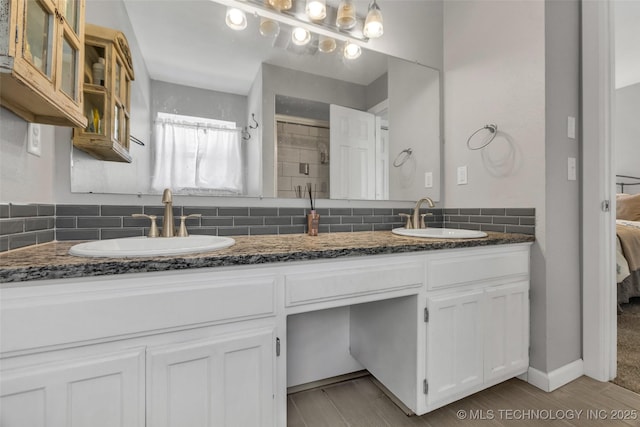 19912 E 36th St S, Broken Arrow, OK 74014 - ensuite bathroom featuring decorative backsplash, double vanity, and wood finished floors