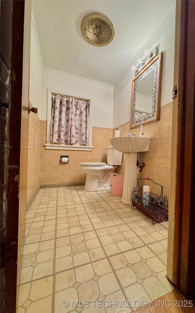 519 N 15th St, Muskogee, OK 74401 - half bathroom with crown molding, tile walls, a wainscoted wall, and tile patterned flooring