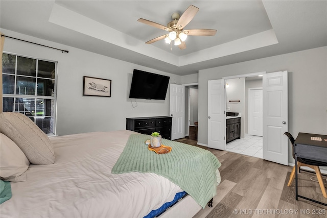 14900 E 88th St N, Owasso, OK 74055 - bedroom featuring a raised ceiling, light wood finished floors, ceiling fan, and connected bathroom
