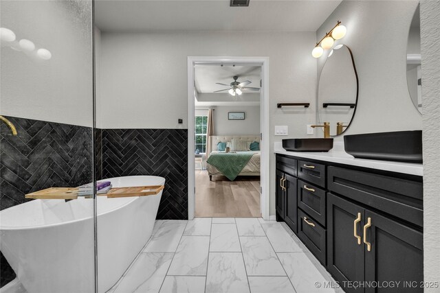 14900 E 88th St N, Owasso, OK 74055 - bathroom with tile walls, ceiling fan, vanity, a freestanding tub, and ensuite bathroom