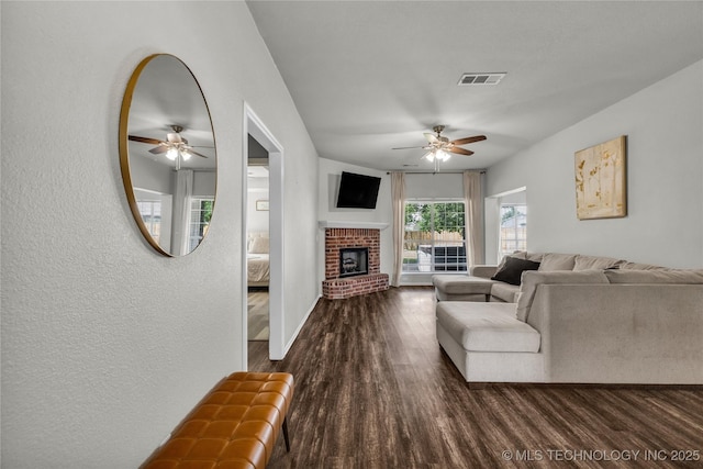 14900 E 88th St N, Owasso, OK 74055 - living room featuring a ceiling fan, dark wood finished floors, a textured wall, and a brick fireplace