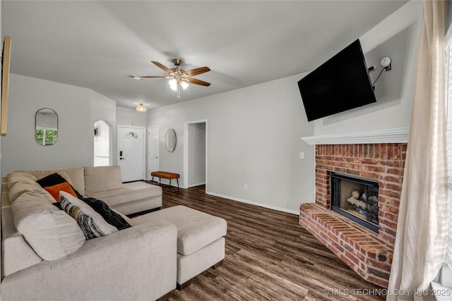 14900 E 88th St N, Owasso, OK 74055 - living area with ceiling fan, dark wood-style floors, a brick fireplace, and arched walkways