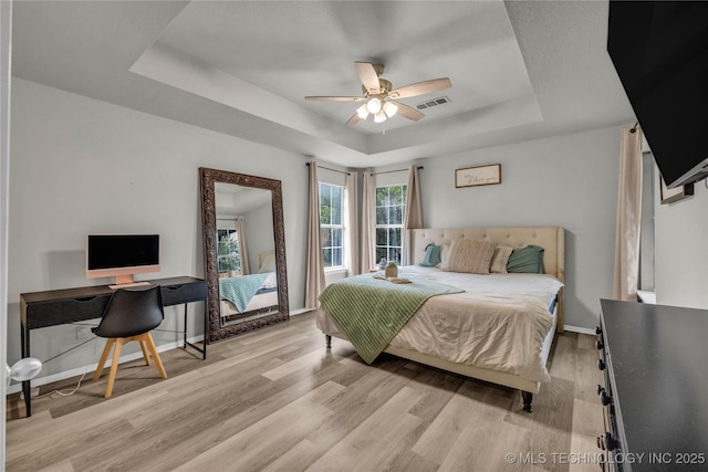 14900 E 88th St N, Owasso, OK 74055 - bedroom featuring a tray ceiling, light wood-style floors, a desk, and ceiling fan
