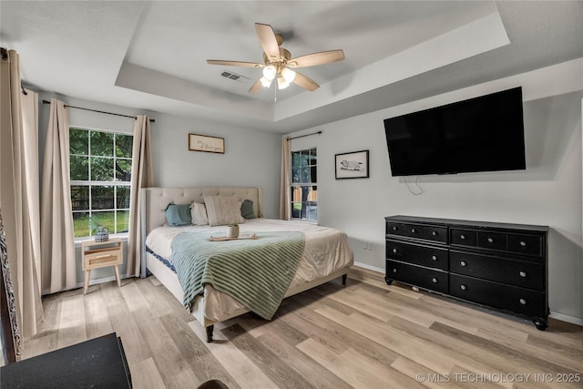 14900 E 88th St N, Owasso, OK 74055 - bedroom featuring a raised ceiling, wood finished floors, and a ceiling fan