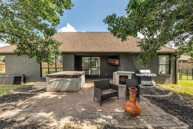 14900 E 88th St N, Owasso, OK 74055 - back of property featuring a hot tub, brick siding, an outdoor fireplace, a patio, and roof with shingles