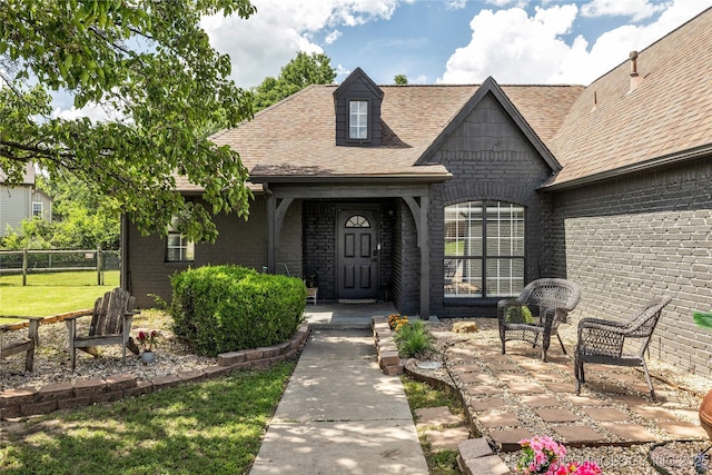 14900 E 88th St N, Owasso, OK 74055 - property entrance with brick siding, a shingled roof, and covered porch