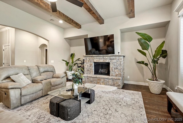10611 N 159th E Ave, Owasso, OK 74055 - living room with arched walkways, wood finished floors, a ceiling fan, beamed ceiling, and a stone fireplace