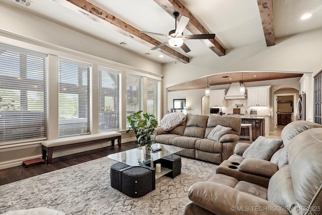10611 N 159th E Ave, Owasso, OK 74055 - living area with arched walkways, ceiling fan, dark wood-style floors, plenty of natural light, and beamed ceiling