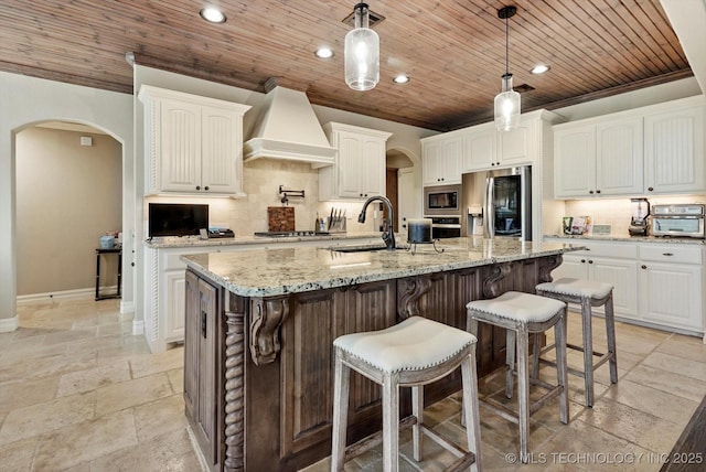 10611 N 159th E Ave, Owasso, OK 74055 - kitchen with appliances with stainless steel finishes, arched walkways, custom range hood, stone tile floors, and wood ceiling
