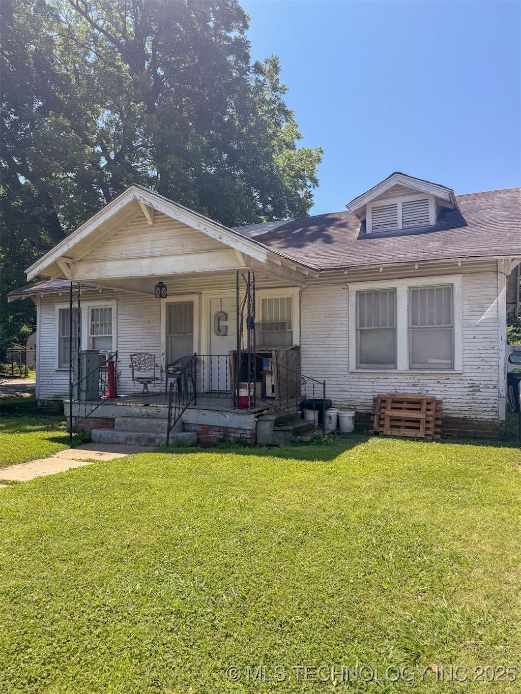 731 E 14th, Ada, OK 74820 - view of front of property with brick siding, a front yard, and covered porch