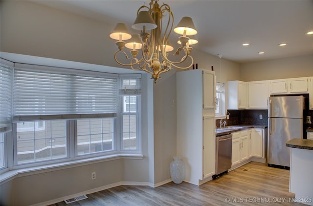 1420 S Frisco Ave Unit 6, Tulsa, OK 74119 - kitchen featuring appliances with stainless steel finishes, dark countertops, light wood-style flooring, white cabinetry, and recessed lighting