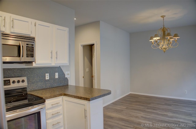 1420 S Frisco Ave Unit 6, Tulsa, OK 74119 - kitchen with stainless steel appliances, dark countertops, a chandelier, white cabinetry, and dark wood finished floors