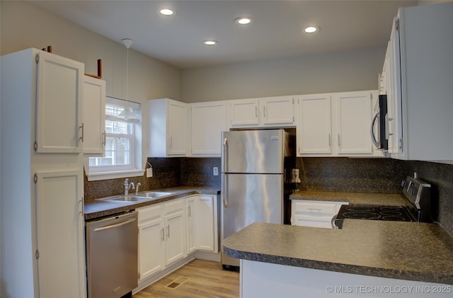 1420 S Frisco Ave Unit 6, Tulsa, OK 74119 - kitchen with stainless steel appliances, dark countertops, a peninsula, white cabinetry, and recessed lighting