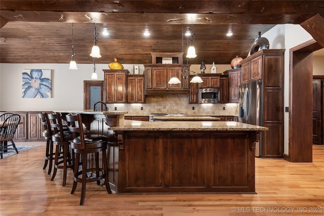 13380 S Garrett St, Sapulpa, OK 74066 - kitchen with appliances with stainless steel finishes, a large island, light wood-style floors, light stone countertops, and tasteful backsplash