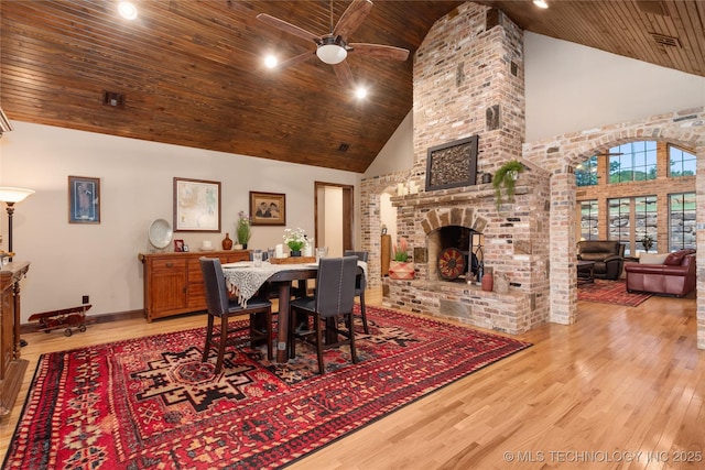 13380 S Garrett St, Sapulpa, OK 74066 - dining space featuring high vaulted ceiling, wood ceiling, a ceiling fan, wood finished floors, and a brick fireplace