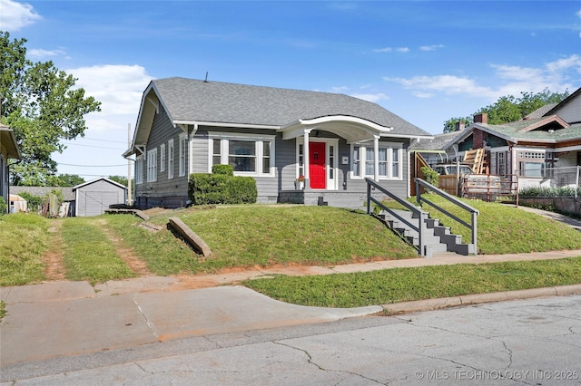 212 S Phoenix Ave, Tulsa, OK 74127 - bungalow-style home with a front yard, roof with shingles, and a garage