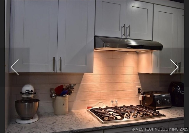 610 W Delaware St, Tahlequah, OK 74464 - kitchen featuring under cabinet range hood, decorative backsplash, stainless steel gas stovetop, and light stone counters