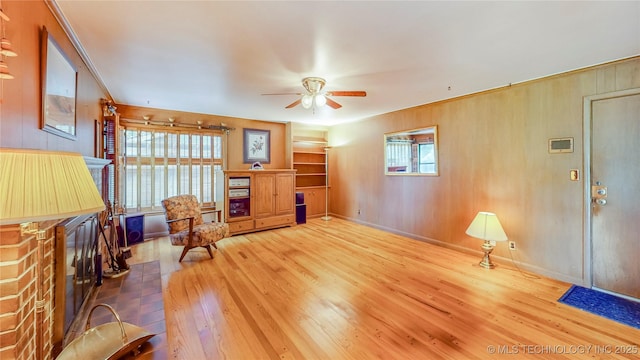 4040 E 46th Pl, Tulsa, OK 74135 - living room with wood-type flooring, a ceiling fan, and wood walls