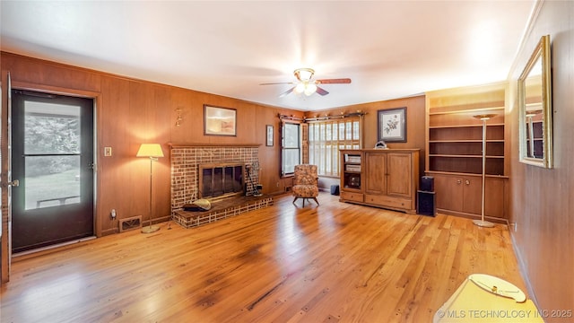 4040 E 46th Pl, Tulsa, OK 74135 - living area with ceiling fan, light wood-style floors, a brick fireplace, and wood walls