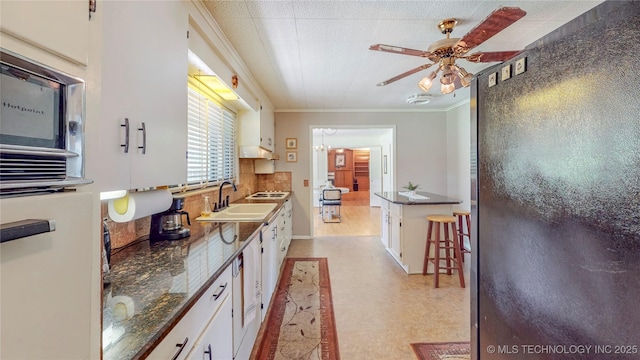 4040 E 46th Pl, Tulsa, OK 74135 - kitchen with light flooring, a ceiling fan, white cabinetry, ornamental molding, and oven