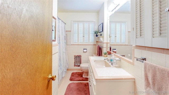 4040 E 46th Pl, Tulsa, OK 74135 - bathroom with healthy amount of natural light, vanity, tile patterned flooring, tile walls, and heating unit