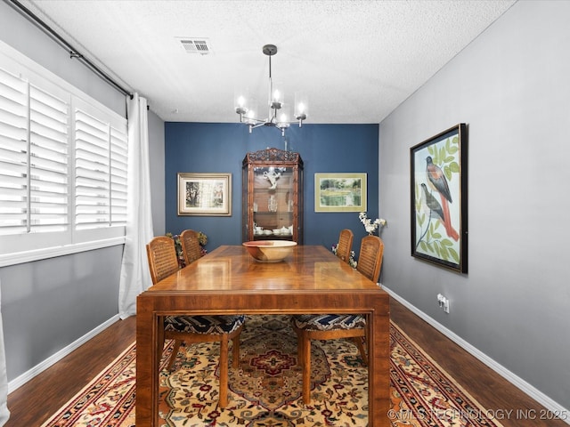 1726 Harned Dr, Bartlesville, OK 74006 - dining area with wood finished floors, a textured ceiling, and a chandelier