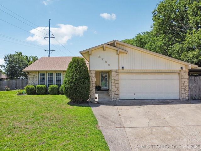 8736 E 59th St, Tulsa, OK 74145 - view of front facade featuring stone siding, an attached garage, and driveway