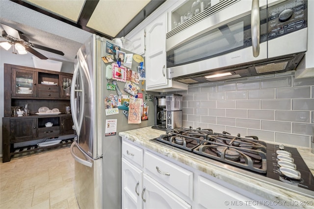 8736 E 59th St, Tulsa, OK 74145 - kitchen with stainless steel appliances, backsplash, ceiling fan, white cabinetry, and light stone countertops