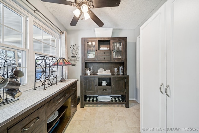 8736 E 59th St, Tulsa, OK 74145 - bar with a textured ceiling, a ceiling fan, and light stone finish flooring