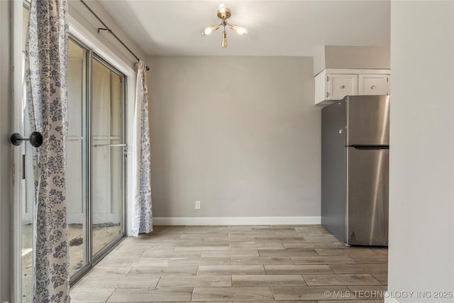 4660 E 68th St Unit 179, Tulsa, OK 74136 - kitchen with freestanding refrigerator, white cabinetry, and wood finish floors