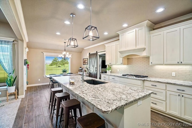 14610 N 144th E Ave, Collinsville, OK 74021 - kitchen featuring stainless steel gas cooktop, recessed lighting, a center island with sink, decorative backsplash, and light stone countertops