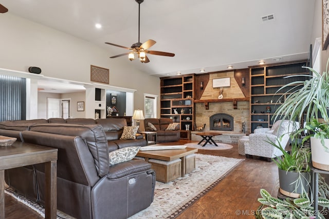 30150 S County Road 4430, Stigler, OK 74462 - living area featuring a ceiling fan, dark wood-type flooring, a stone fireplace, built in features, and high vaulted ceiling