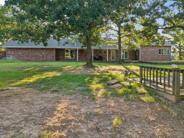 30150 S County Road 4430, Stigler, OK 74462 - back of property with brick siding, a yard, and roof with shingles