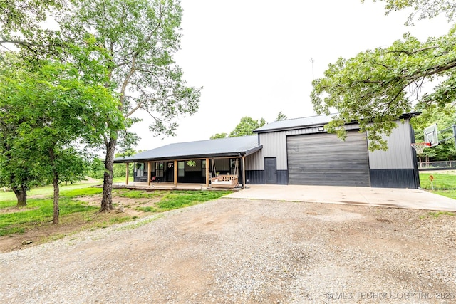 348550 E Parkside Dr, Pawnee, OK 74058 - view of front of property with dirt driveway, a porch, a detached garage, and a metal roof