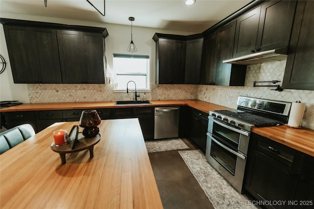 348550 E Parkside Dr, Pawnee, OK 74058 - kitchen with butcher block countertops, stainless steel appliances, under cabinet range hood, tasteful backsplash, and decorative light fixtures
