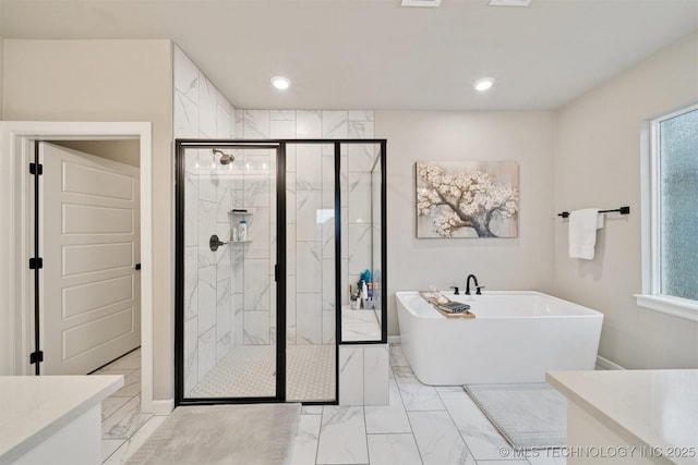 716 E 126th St, Jenks, OK 74037 - bathroom featuring marble finish flooring, a soaking tub, vanity, healthy amount of natural light, and recessed lighting