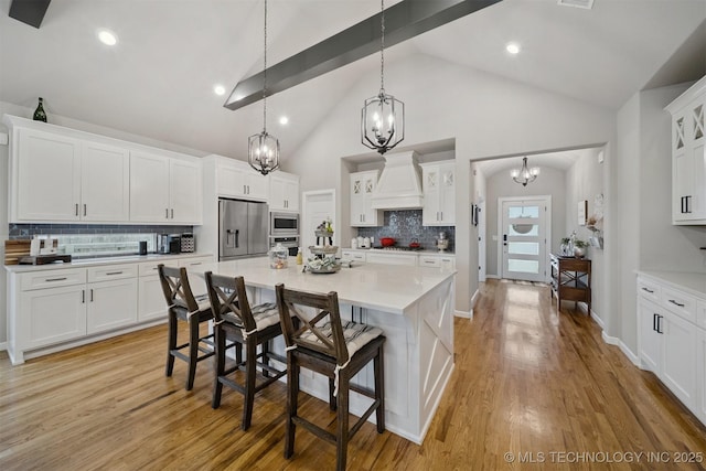 716 E 126th St, Jenks, OK 74037 - kitchen with appliances with stainless steel finishes, custom range hood, a chandelier, backsplash, and high vaulted ceiling