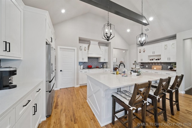 716 E 126th St, Jenks, OK 74037 - kitchen with custom exhaust hood, a kitchen bar, a chandelier, light countertops, and recessed lighting
