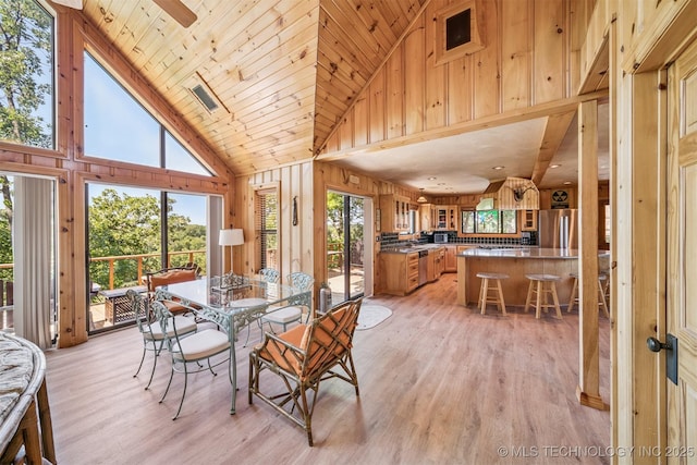 69125 E 252nd Rd, Wyandotte, OK 74370 - dining room featuring high vaulted ceiling, wooden walls, light wood-type flooring, and wood ceiling