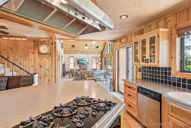 69125 E 252nd Rd, Wyandotte, OK 74370 - kitchen featuring dishwasher, wood walls, wall chimney exhaust hood, a ceiling fan, and black gas stovetop