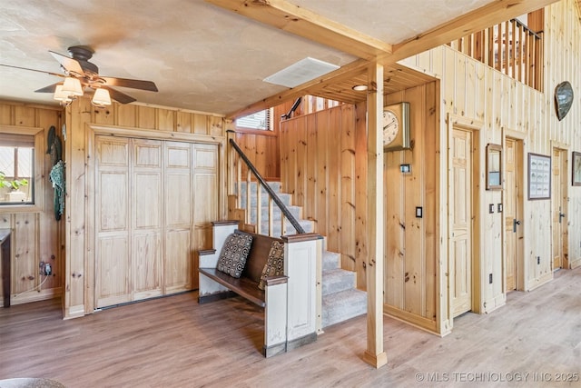 69125 E 252nd Rd, Wyandotte, OK 74370 - staircase featuring wooden walls, wood finished floors, ceiling fan, and plenty of natural light