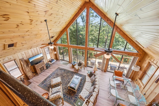 69125 E 252nd Rd, Wyandotte, OK 74370 - living area featuring high vaulted ceiling, ceiling fan, plenty of natural light, wooden walls, and wooden ceiling